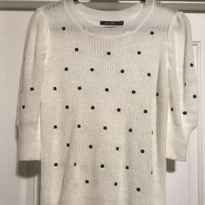 White sweater with black polka dots.
